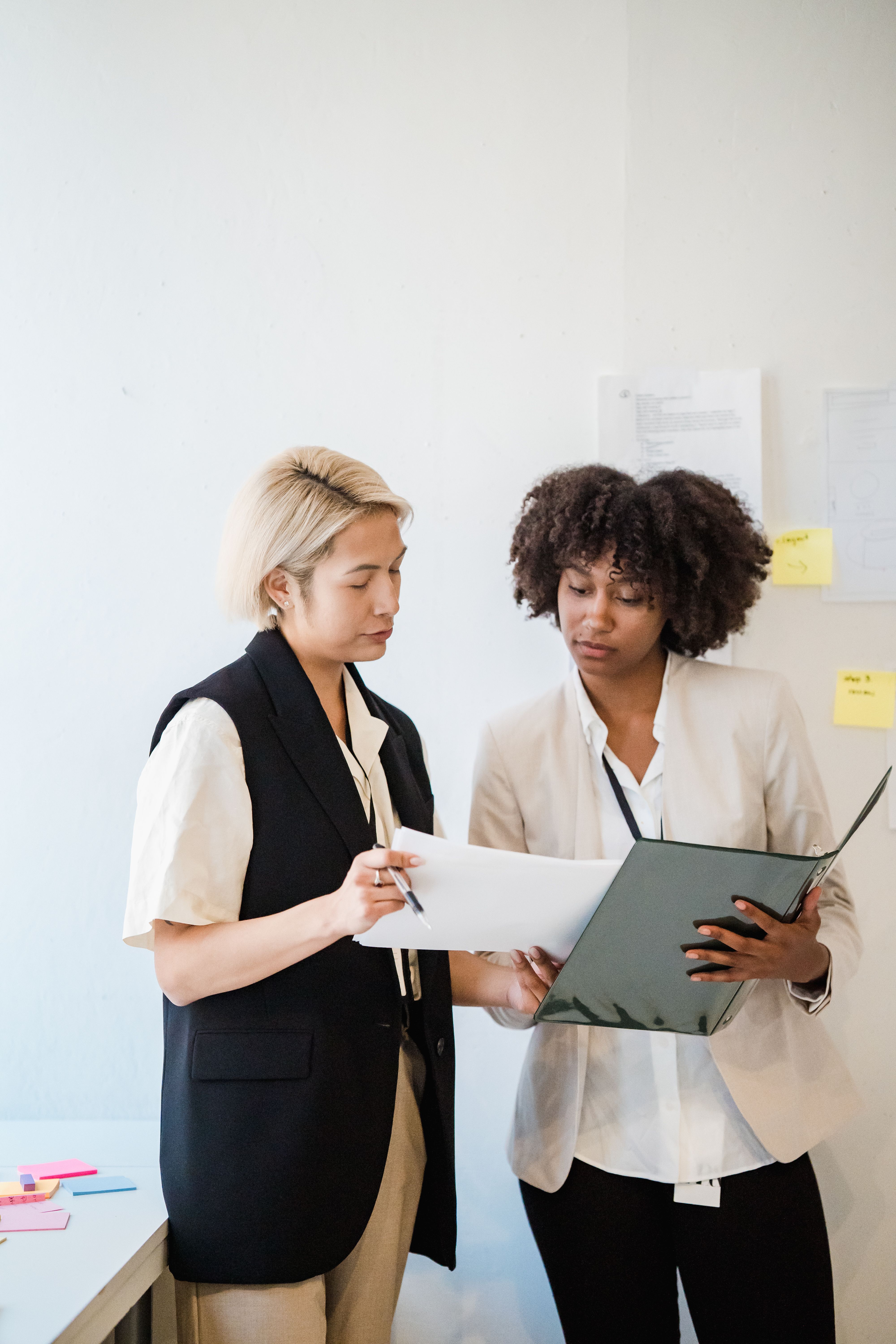 Two professional women reviewing documents together in an office
